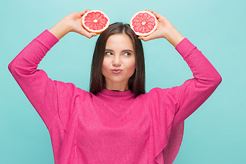 Image showing Pretty woman with delicious grapefruit in her arms.