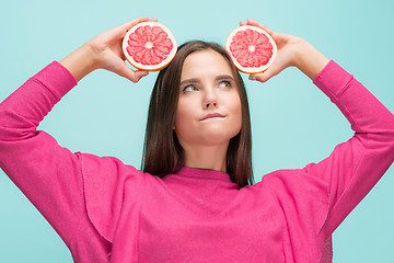 Image showing Pretty woman with delicious grapefruit in her arms.