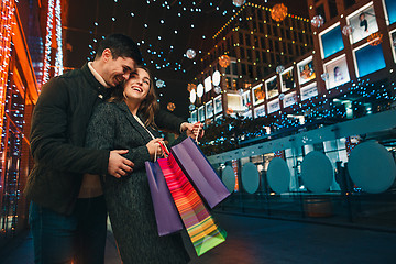 Image showing The happy couple with shopping bags enjoying night at city background