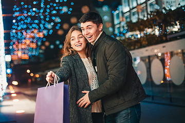 Image showing The happy couple with shopping bags enjoying night at city background