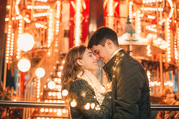 Image showing Young couple kissing and hugging outdoor in night street at christmas time