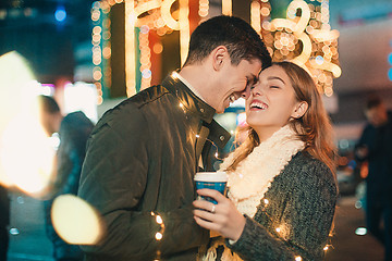 Image showing Young couple kissing and hugging outdoor in night street at christmas time