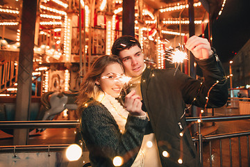 Image showing Young couple kissing and hugging outdoor in night street at christmas time