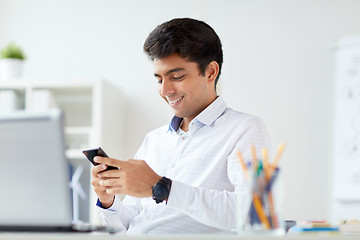 Image showing happy businessman with smartphone at office