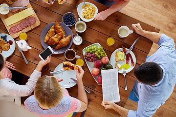 Image showing people with smartphones eating food at table