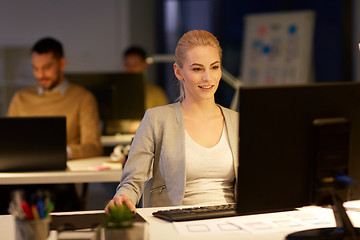 Image showing businesswoman at computer working at night office