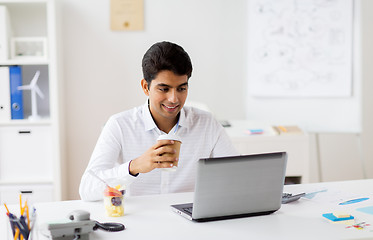 Image showing businessman with laptop drinking coffee at office