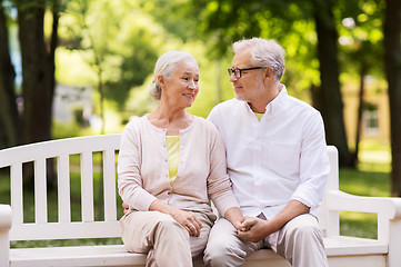 Image showing happy senior couple sitting on bench at park