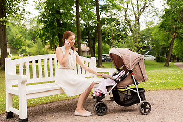 Image showing mother with stroller calling on smartphone at park