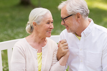 Image showing happy senior couple sitting on bench at park