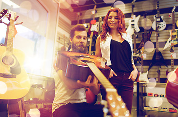 Image showing couple of musicians with guitar at music store