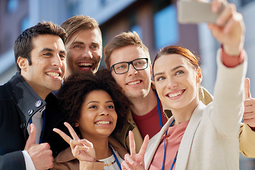 Image showing business team with conference badges taking selfie