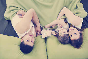 Image showing happy family relaxing in bed