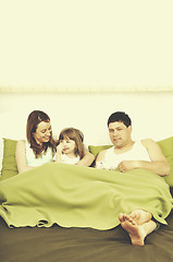 Image showing happy family relaxing in bed