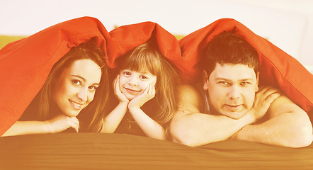 Image showing happy family relaxing in bed