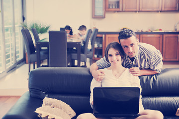 Image showing happy young family have fun and working on laptop at home