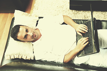 Image showing Portrait of a relaxed young guy using laptop at home