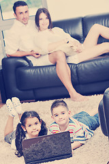 Image showing happy young family have fun and working on laptop at home