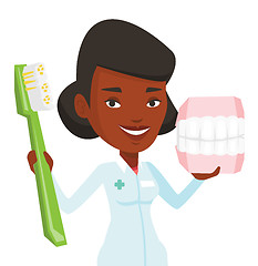 Image showing Dentist with dental jaw model and toothbrush.