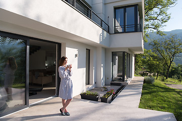 Image showing woman in a bathrobe enjoying morning coffee