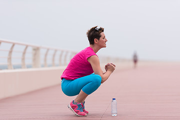 Image showing woman stretching and warming up on the promenade