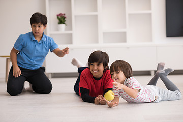 Image showing boys having fun with an apple on the floor