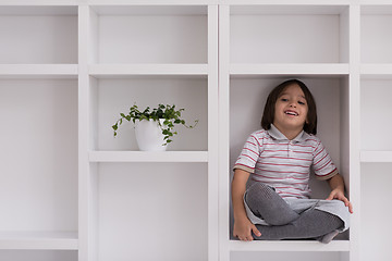 Image showing young boy posing on a shelf