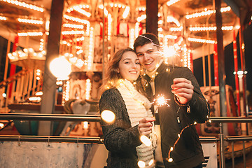 Image showing Young couple kissing and hugging outdoor in night street at christmas time