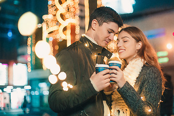 Image showing Young couple kissing and hugging outdoor in night street at christmas time