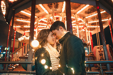 Image showing Young couple kissing and hugging outdoor in night street at christmas time