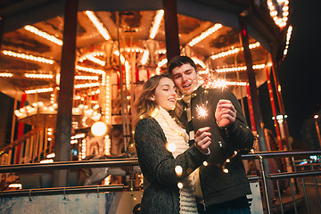 Image showing Young couple kissing and hugging outdoor in night street at christmas time