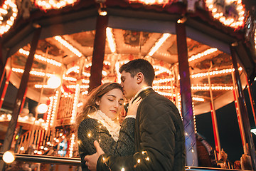 Image showing Young couple kissing and hugging outdoor in night street at christmas time