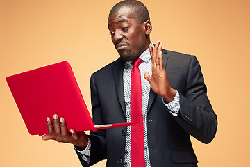 Image showing Handsome Afro American man sitting and using a laptop