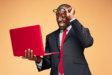 Image showing Handsome Afro American man sitting and using a laptop