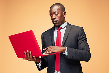 Image showing Handsome Afro American man sitting and using a laptop