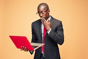 Image showing Handsome Afro American man sitting and using a laptop