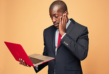 Image showing Handsome Afro American man sitting and using a laptop