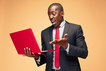 Image showing Handsome Afro American man sitting and using a laptop