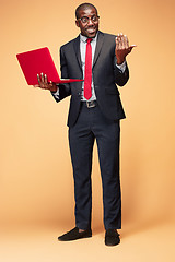 Image showing Handsome Afro American man sitting and using a laptop