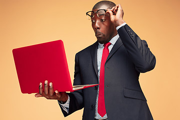 Image showing Handsome Afro American man sitting and using a laptop