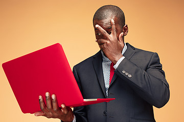 Image showing Handsome Afro American man sitting and using a laptop