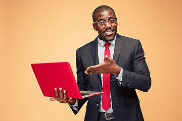 Image showing Handsome Afro American man sitting and using a laptop