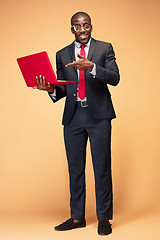 Image showing Handsome Afro American man sitting and using a laptop