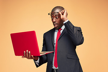 Image showing Handsome Afro American man sitting and using a laptop