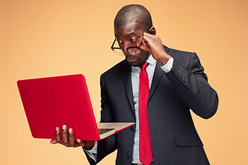 Image showing Handsome Afro American man sitting and using a laptop