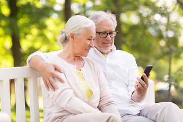 Image showing happy senior couple with smartphone at park