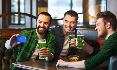 Image showing friends taking selfie with green beer at pub