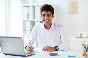 Image showing businessman in earphones working at office