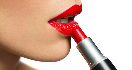 Image showing close up of woman applying red lipstick to lips