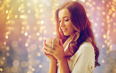 Image showing happy woman with cup of tea or coffee at home